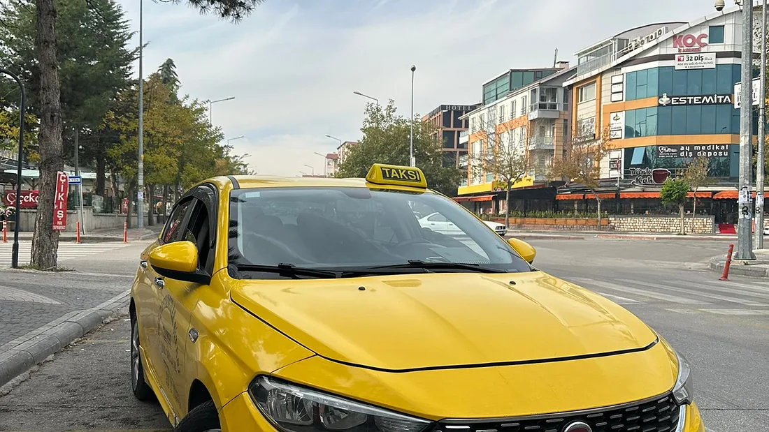 İyaş Taksi Fiat Egea taksi Isparta şehir merkezinde, binaların önünde